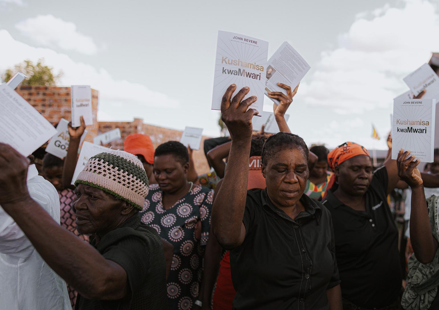 People holding translated books delivered by Messenger International